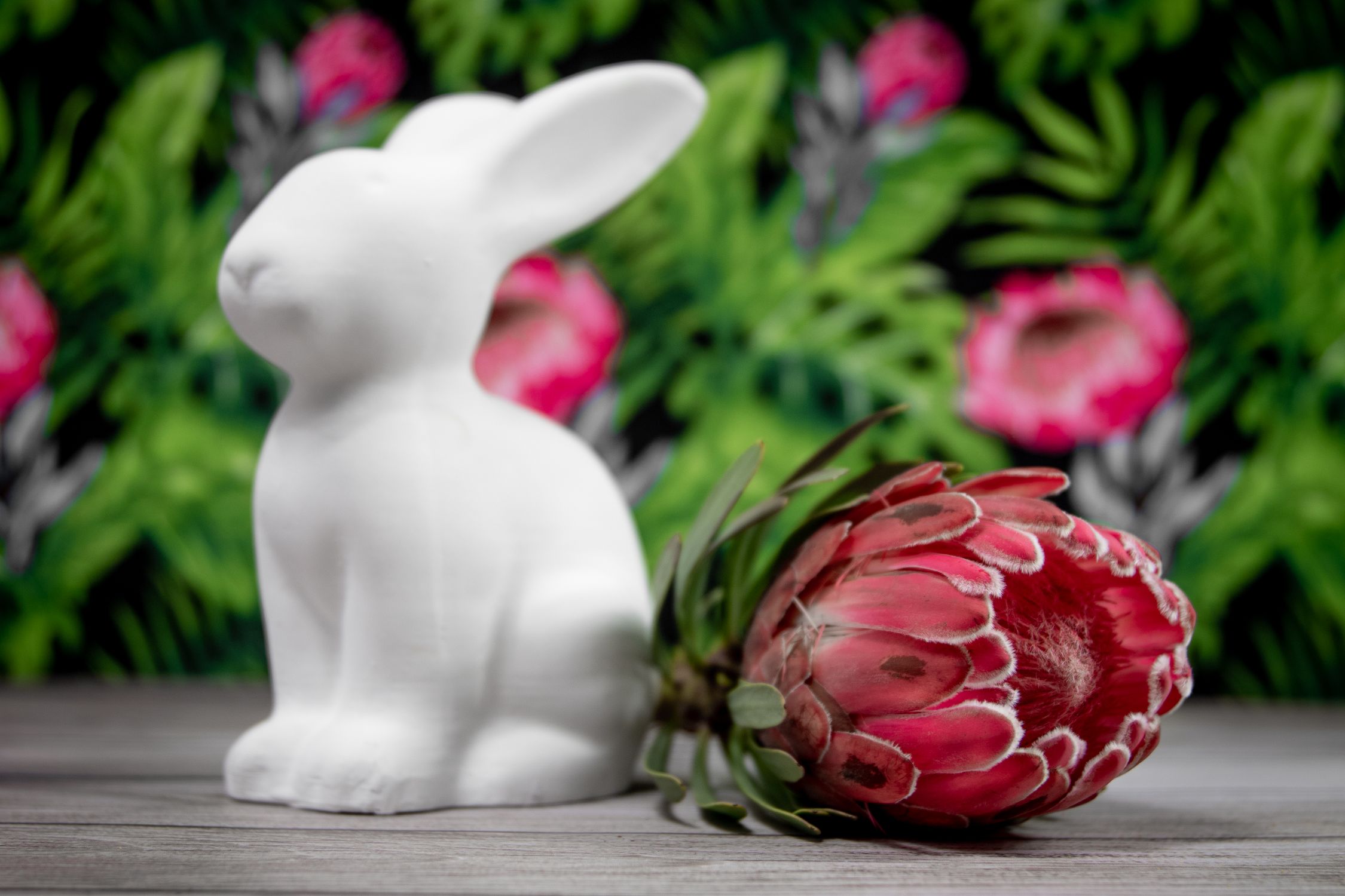 Red Ceramic Rabbit White Ceramic Rabbit Figurine Beside Red Flowers · Free Stock Photo
