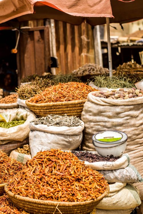 Free Colorful array of spices displayed in sacks at an outdoor market, showcasing variety and texture. Stock Photo