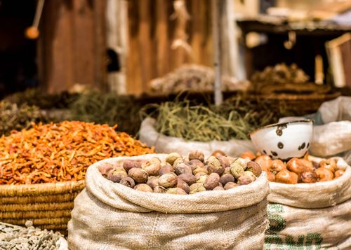 Free Colorful market scene featuring sacks of spices and vegetables, highlighting a lively outdoor market atmosphere. Stock Photo