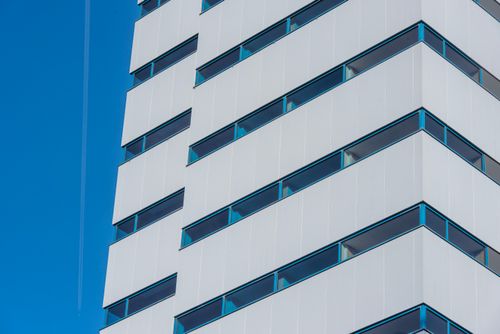 Free Close-up of a modern office building facade against clear blue sky. Stock Photo