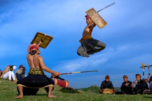 Free Dynamic scene of traditional Indonesian martial arts with performers in Nusa Tenggara Barat. Stock Photo