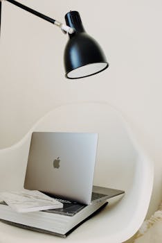 Modern home office scene featuring a laptop, books, and a stylish lamp for a productive environment.