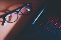 Black Framed Eyeglasses on Black Computer Keyboard
