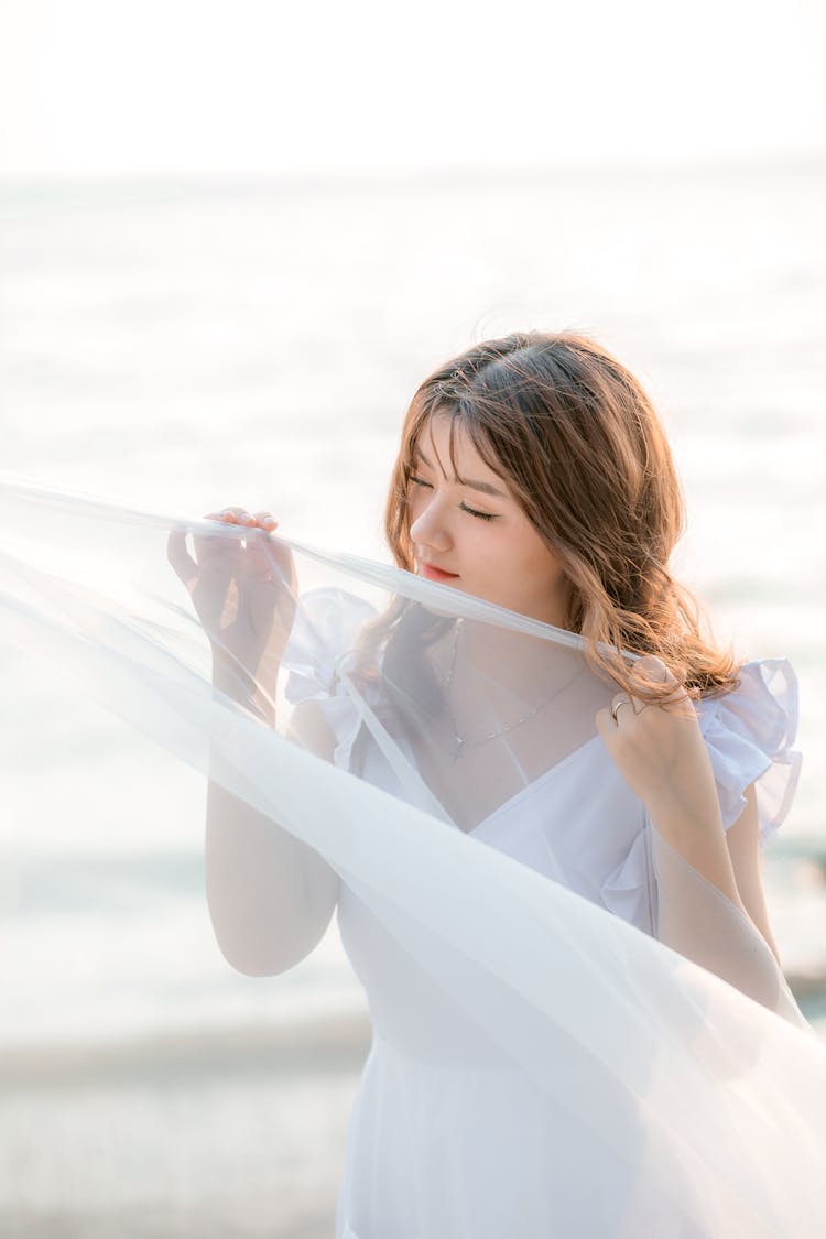 Woman In White Dress Shirt Holding White Sheer Textile