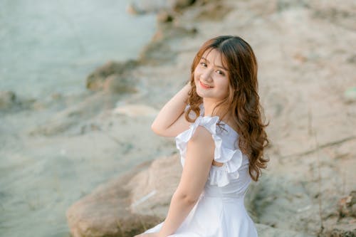 Happy woman in dress on stony ground