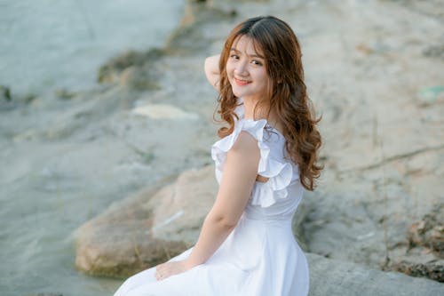 Free Woman in White Dress Sitting Rock Stock Photo
