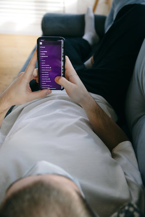 Man Lying Down Holding His Smartphone