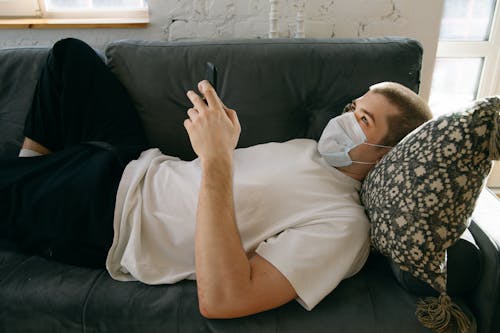 Free Man Lying Down Holding His Mobile Phone Stock Photo