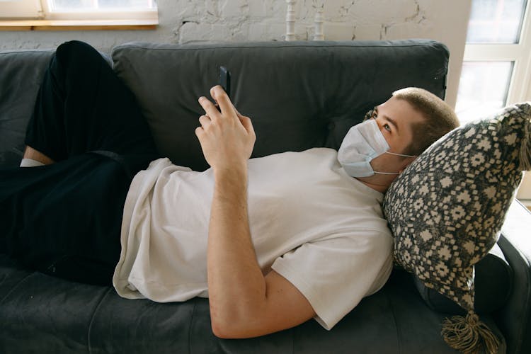 Man Lying Down Holding His Mobile Phone