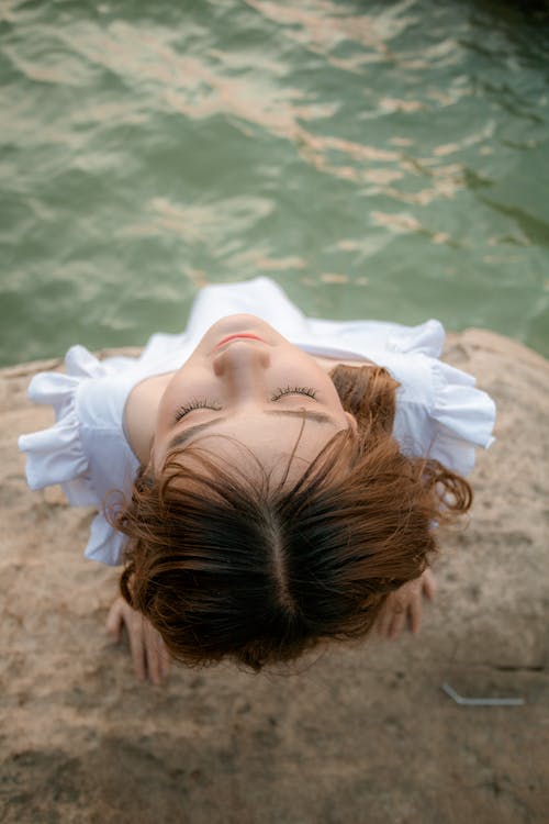 Calm young woman resting near lake