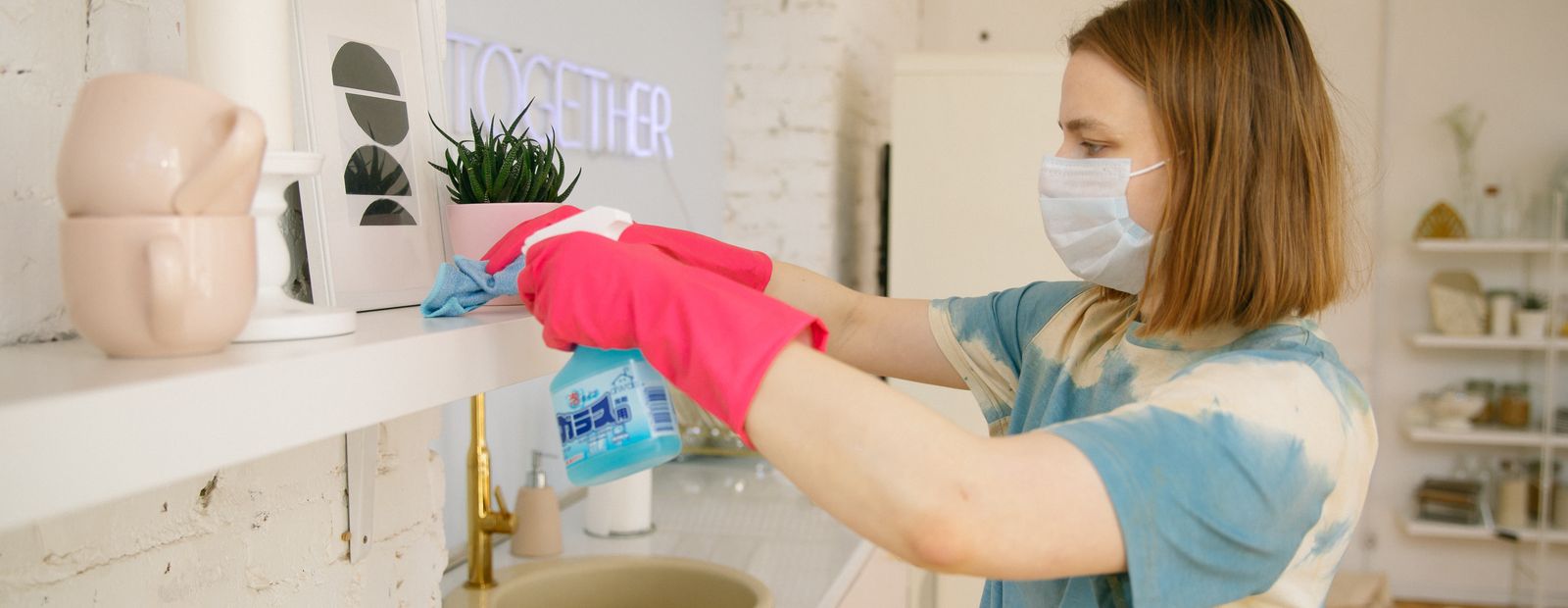 Woman wearing a face mask while cleaning the kitchen
