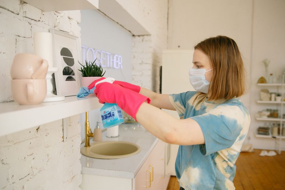 person wearing a mask and gloves wiping down a dusty surface - deep cleaning house after construction person wearing a mask and gloves wiping down a dusty surface - deep cleaning house after construction