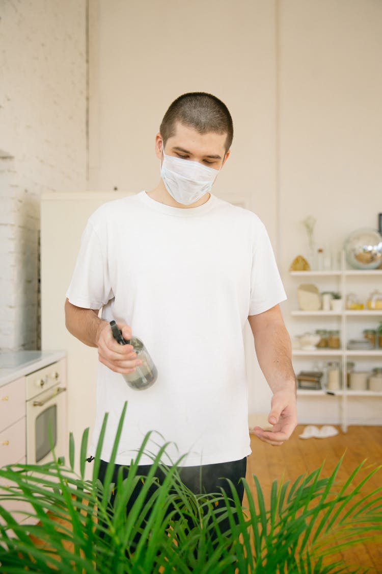 Man In White Crew Neck T Shirt Holding Spray Bottle 