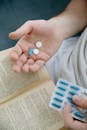Person Holding Blue and White Medicine