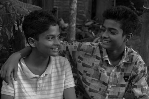 Free Two teenage boys smiling and bonding in a black and white portrait. Stock Photo