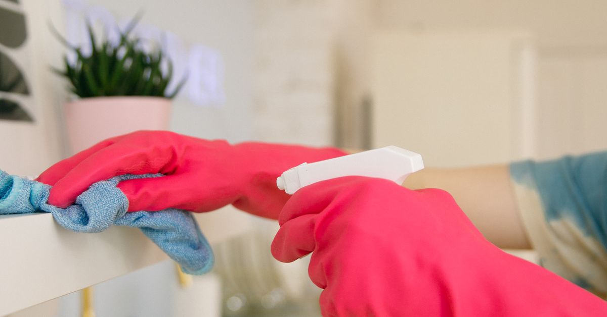 Limpeza diária da cozinha Pessoa limpando prateleira da cozinha com borrifador e pano