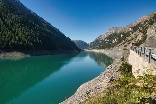 Free Stunning view of the turquoise lake surrounded by mountains in Livigno, Italy. Stock Photo