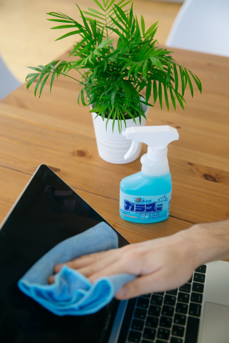 Cleaner wiping a computer screen