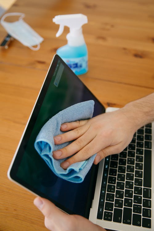 Free Person Cleaning the Laptop Stock Photo