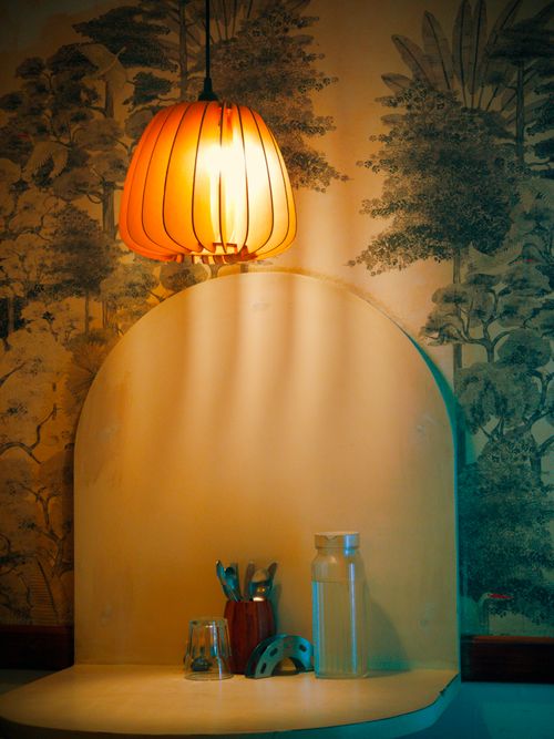 Free Warm lighting over a modern table setting with elegant wallpaper backdrop. Stock Photo