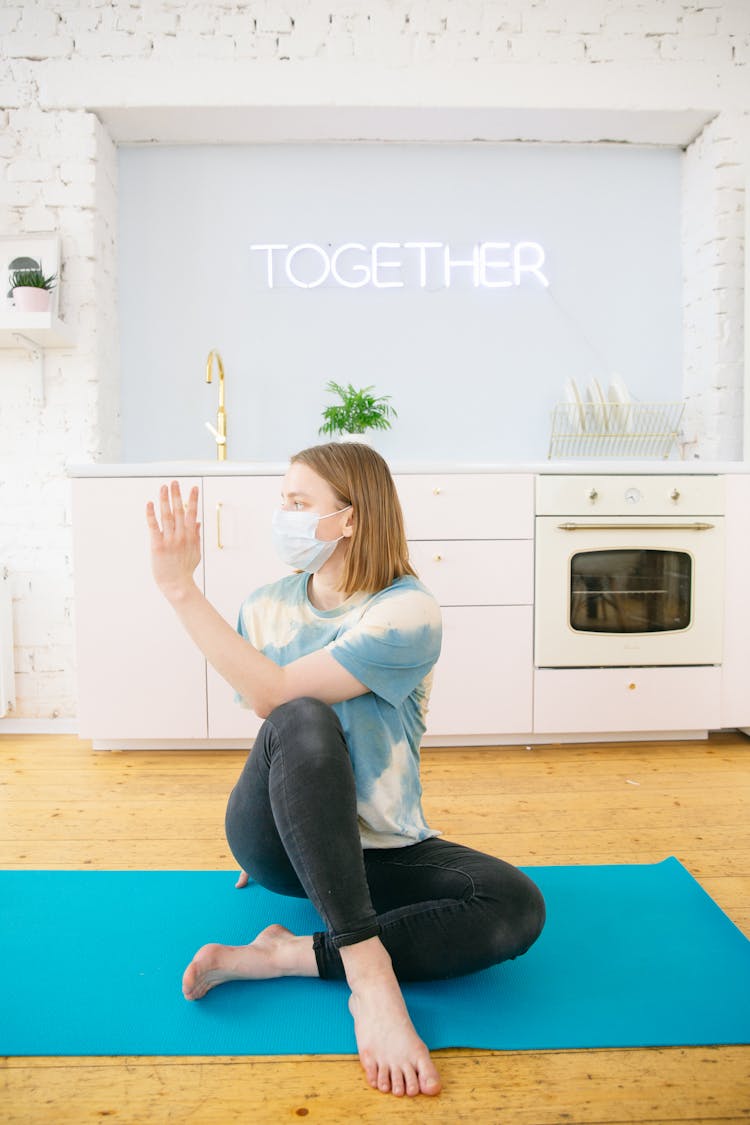 Woman With Face Mask Exercising At Home