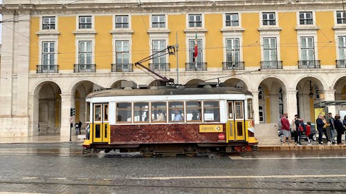 Free Yellow and Red Tram Near White Concrete Building Stock Photo