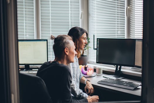 A couple collaborating on projects in a cozy home office setting with computers.
