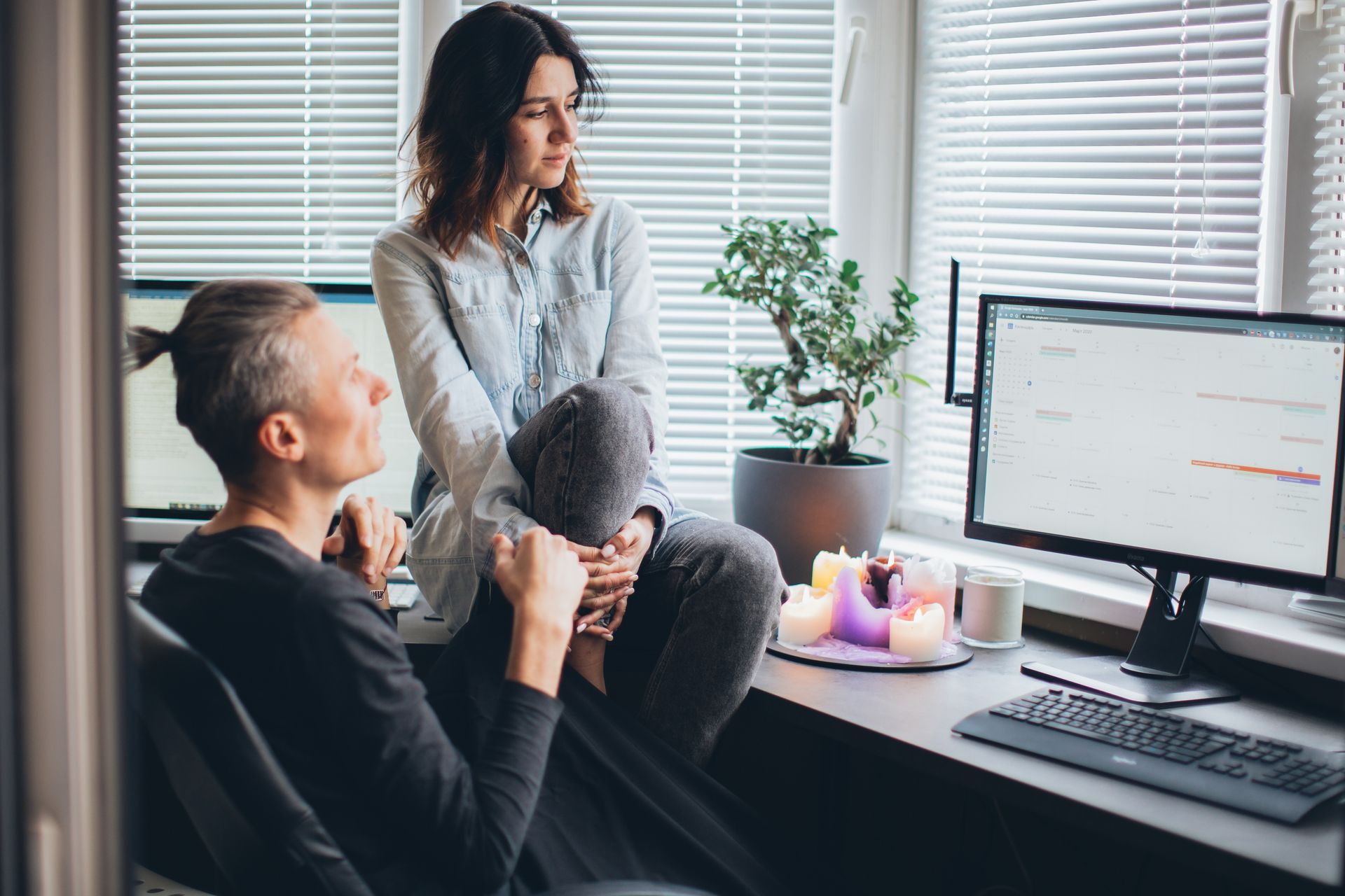 Two people in a home office setting having a discussion about a project, exuding a relaxed and collaborative atmosphere.