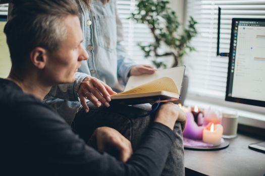 A couple enjoys remote work together, surrounded by warmth and technology in a cozy home office setting.