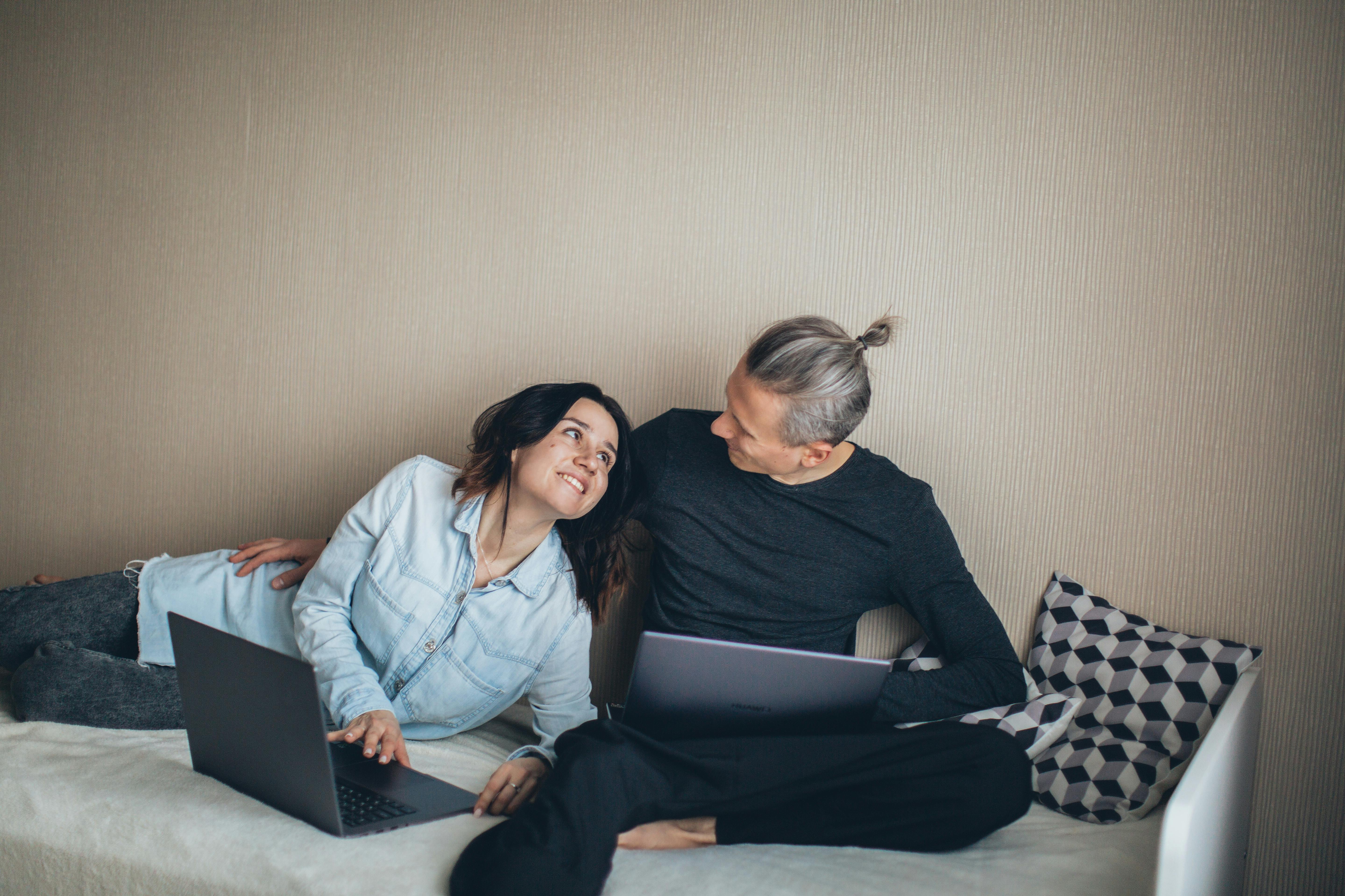 couple sitting on the bed working