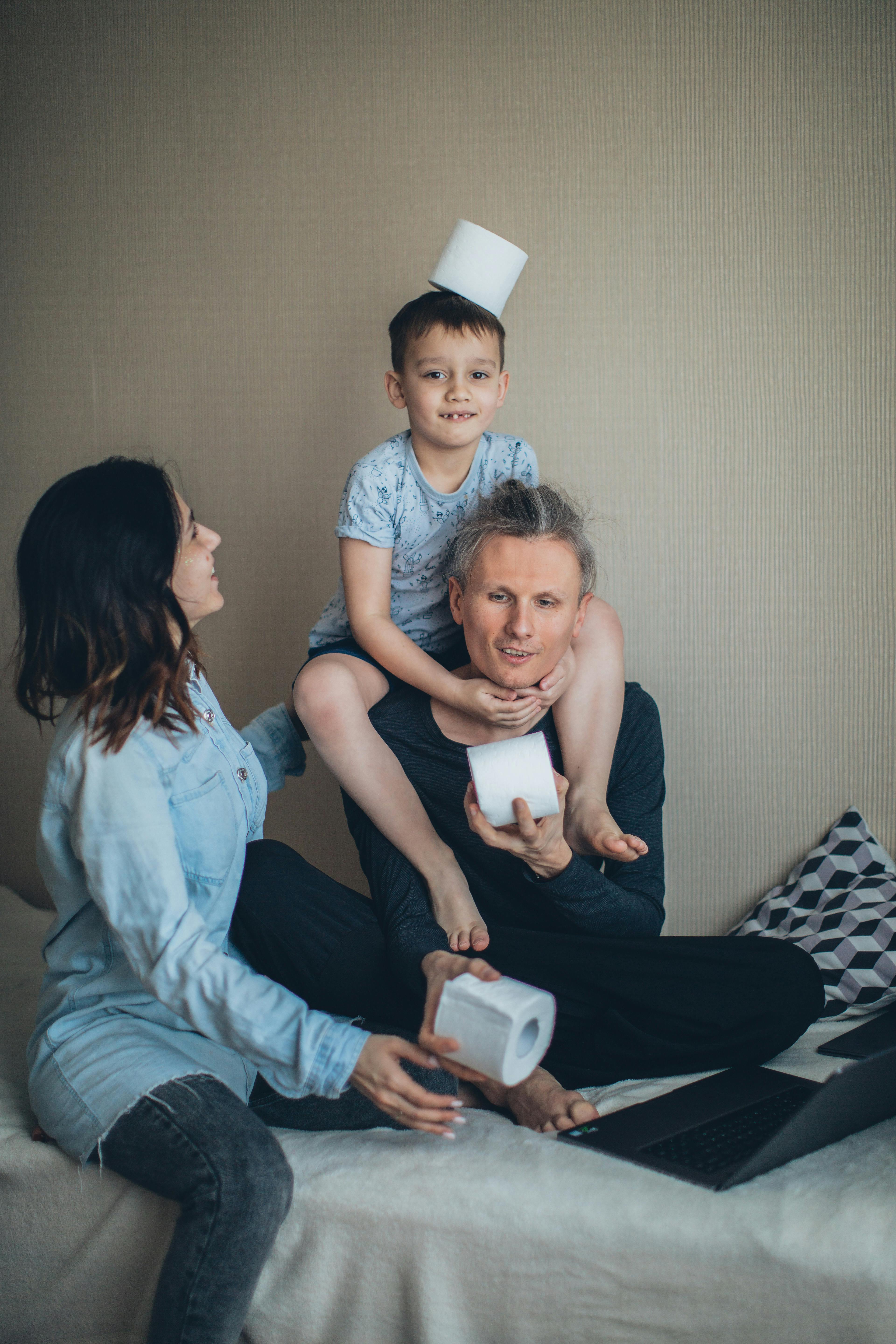 A playful family moment indoors with laughter and toilet paper fun.
