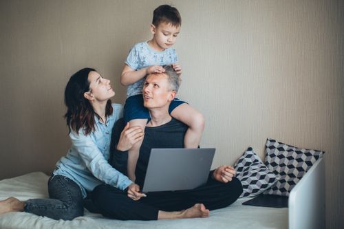 Free A joyful family moment indoors featuring a father, mother, and son bonding together with a laptop. Stock Photo