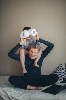 Joyful father-son playtime with makeshift binoculars made from toilet paper rolls.