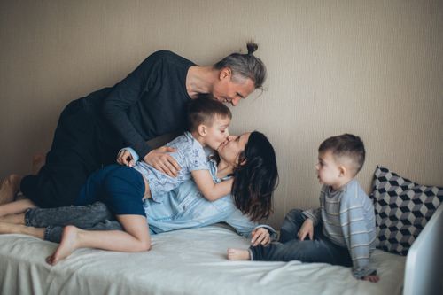 Free A joyful family shares love and togetherness during playful bonding in a cozy bedroom. Stock Photo