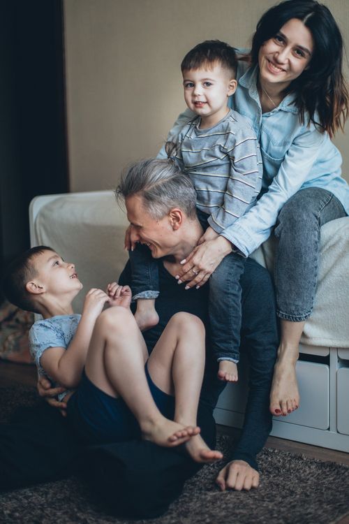 Free A joyful family bonding moment with parents and sons in a cozy indoor setting. Stock Photo
