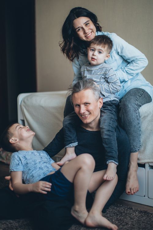 Free A joyful family of four having fun and bonding indoors, capturing love and togetherness. Stock Photo