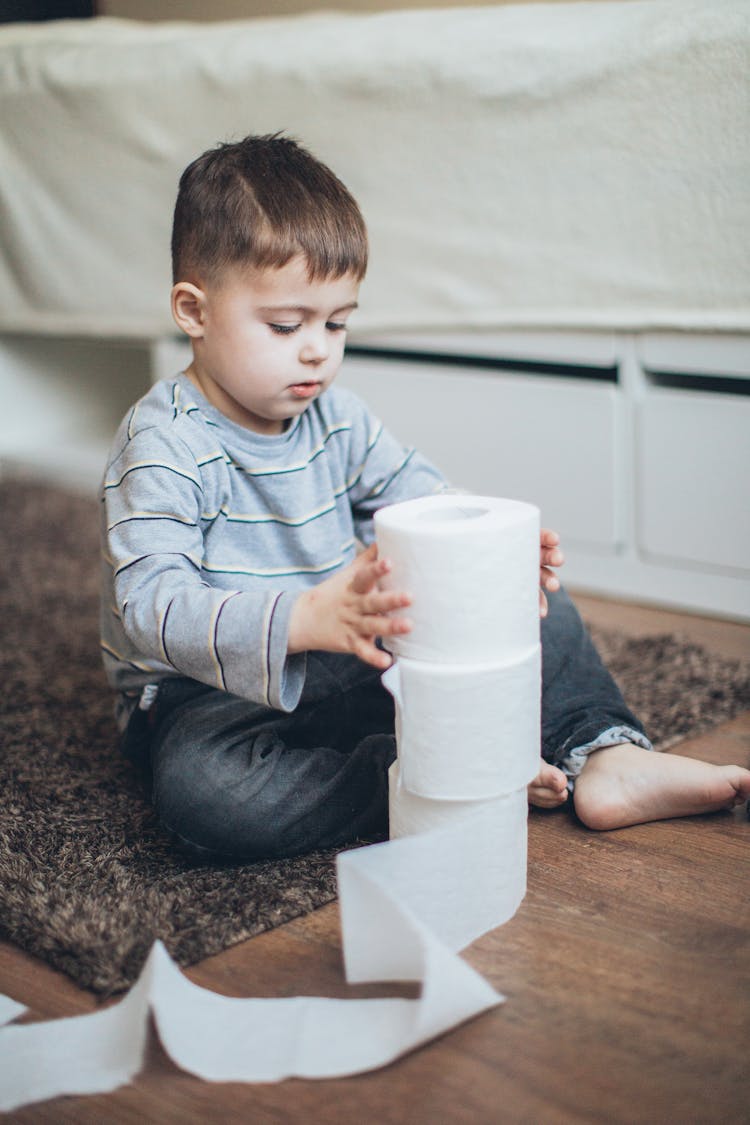 Boy Playing With Toilet Paper Rolls