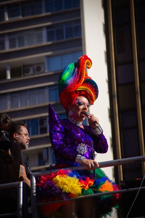 Free Colorful drag performer captivating audience with vibrant costume at outdoor pride celebration. Stock Photo