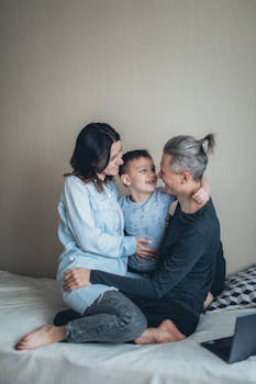 A joyful family bond between parents and their son enjoying quality time on the bed.