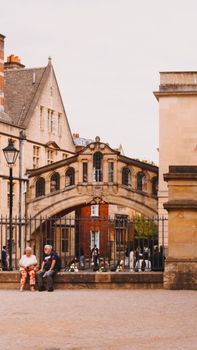 Historic view of the Bridge of Sighs in Oxford, England with people enjoying the street scene.