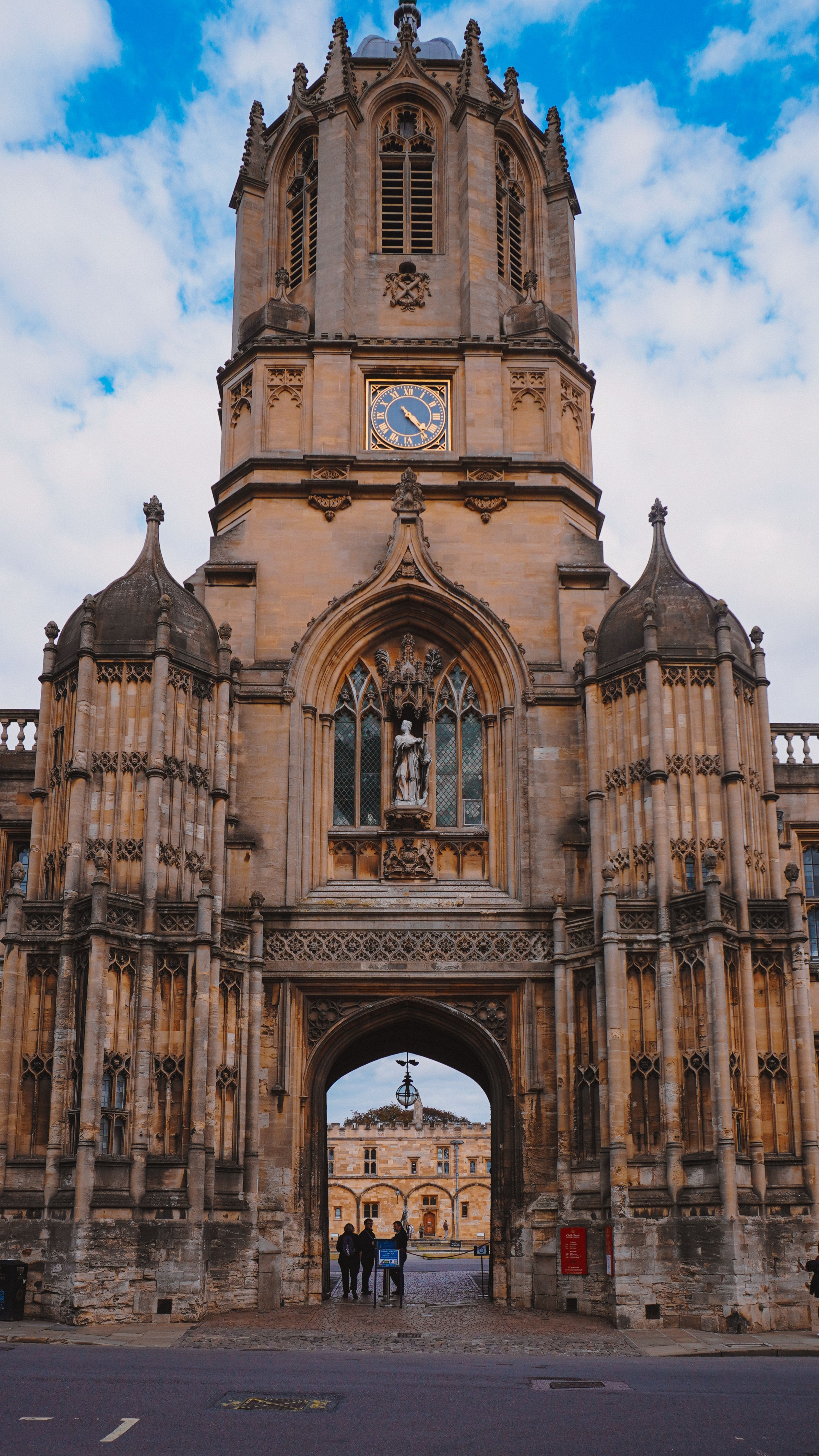 Majestic Gothic tower at Christ Church, Oxford, under a bright blue sky.