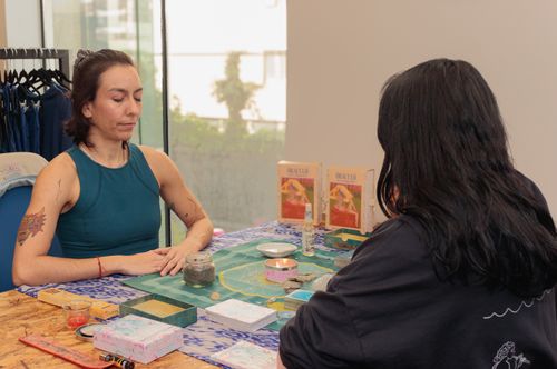 Free Two people engaged in an intimate tarot reading session with oracle cards on a decorated table. Stock Photo