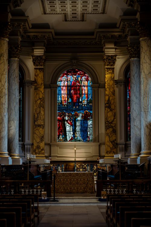 Free Atmospheric interior view of a church in Birmingham, UK, featuring a vibrant stained glass window. Stock Photo
