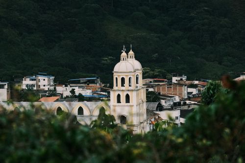 Free Beautiful Colombian town with colonial architecture set against lush green mountains. Stock Photo