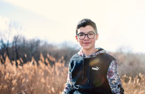 Free A smiling teenager enjoying a sunny autumn day in a natural outdoor setting. Stock Photo