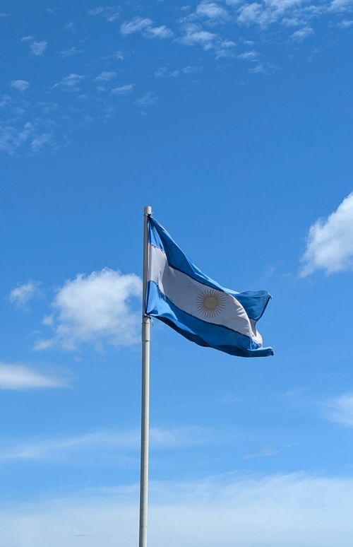 Free The national flag of Argentina waving proudly with a clear sky as the backdrop. Stock Photo