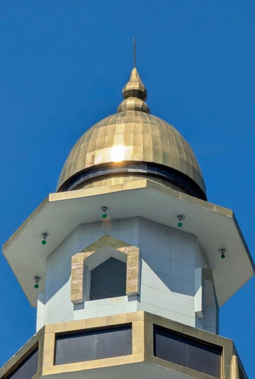 Free Close-up of a mosque's golden dome with a clear blue sky background. Stock Photo