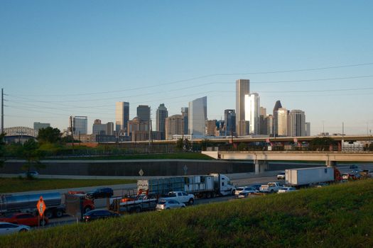 Captivating view of Houston skyline with bustling highway traffic at sunset.