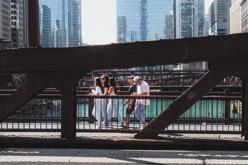 Free Group of pedestrians walking across a steel bridge in downtown Chicago with modern skyscrapers in the background. Stock Photo