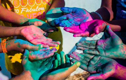 Free An overhead shot of hands covered in colorful powders celebrating Holi, the festival of colors. Stock Photo